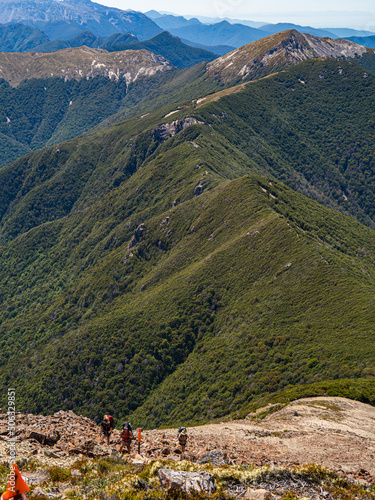 Hiker hiking on mountain top trail ridge line 