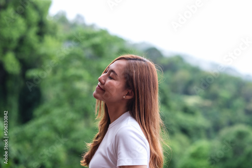 Portrait image of a young woman closed her eyes and enjoy a beautiful mountains and nature view © Farknot Architect