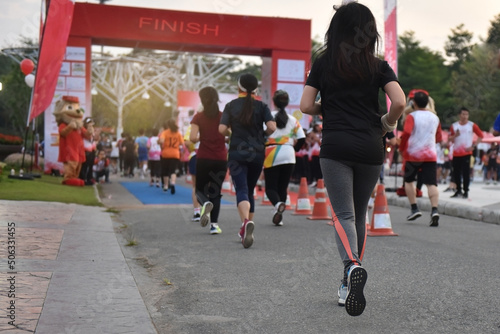 Running crowds of marathon runners, many runners past the start or finish line, women in focus.