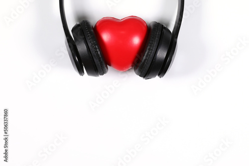 Black headphone with red heart isolated on white background, flat lay photography have copy space.