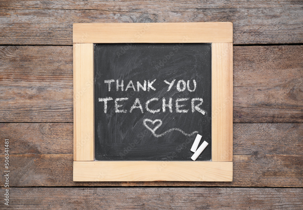 Small blackboard with pieces of chalk and phrase Thank you, teacher on wooden table, top view