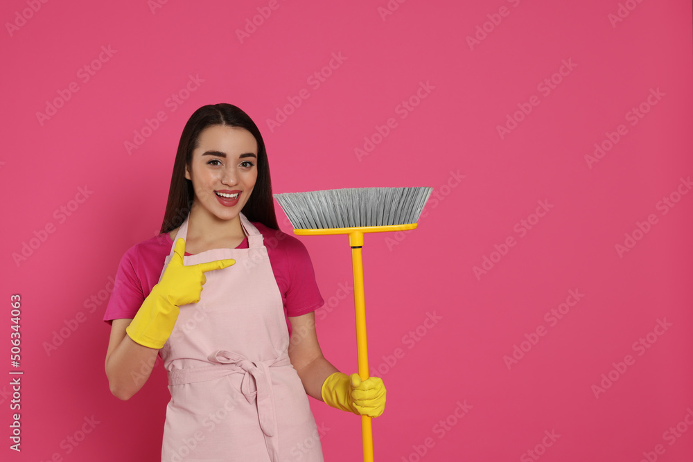 Beautiful young woman with broom on pink background. Space for text Beautiful young woman with broom on pink background. Space for text