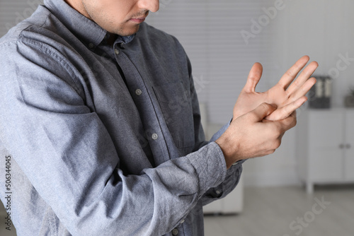 Quadro su tela Man suffering from trigger finger at home, closeup