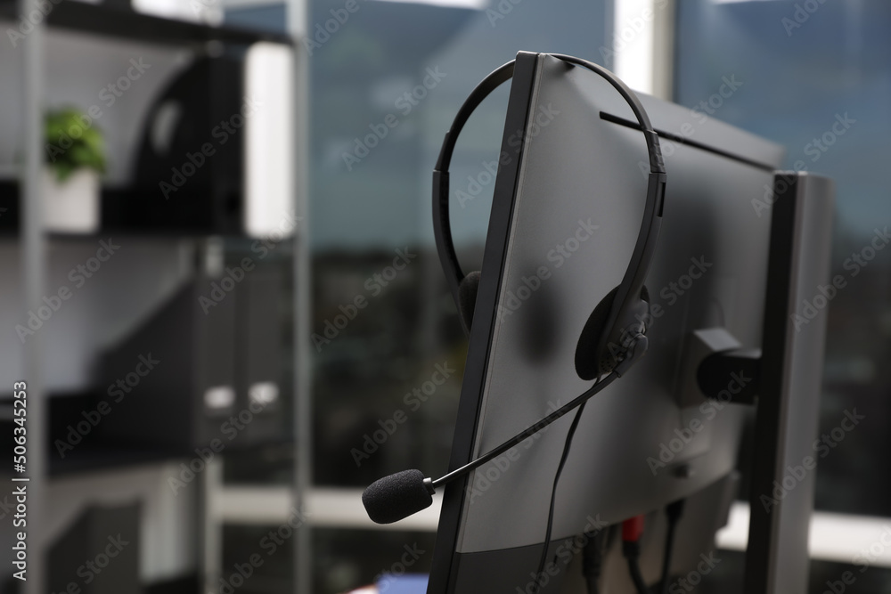 Naklejka premium Modern computer with headset indoors. Hotline service