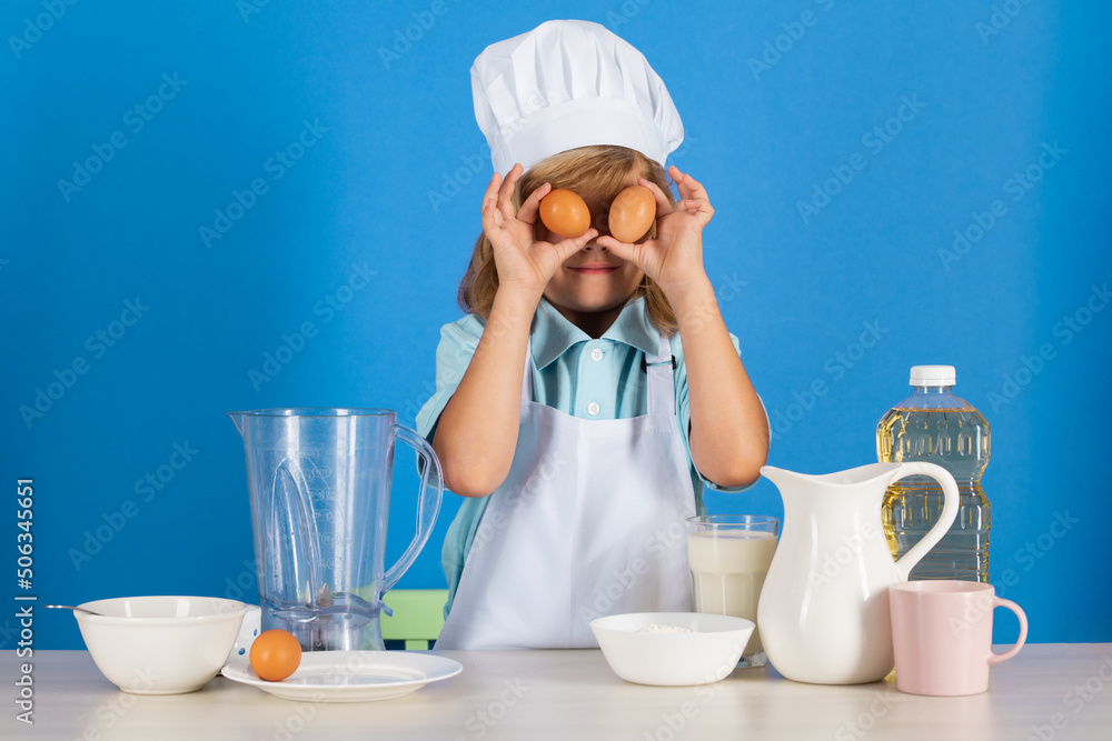 Portrait of chef child in cook hat hold eggs. Cooking at home, kid boy preparing food from vegetable and fruits. Healthy eating. Portrait of chef child in cook hat hold eggs. Cooking at home, kid boy preparing food from vegetable and fruits. Healthy eating.