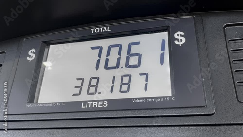 Gas price screen in dollars on fuel pump increasing based on litres, close up