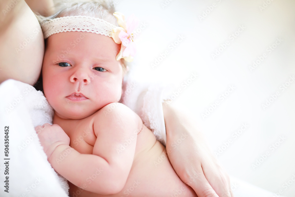 A newborn baby lies in her mother's arms. A beautiful baby of European appearance is sleeping. A newborn baby lies in her mother's arms. A beautiful baby of European appearance is sleeping.