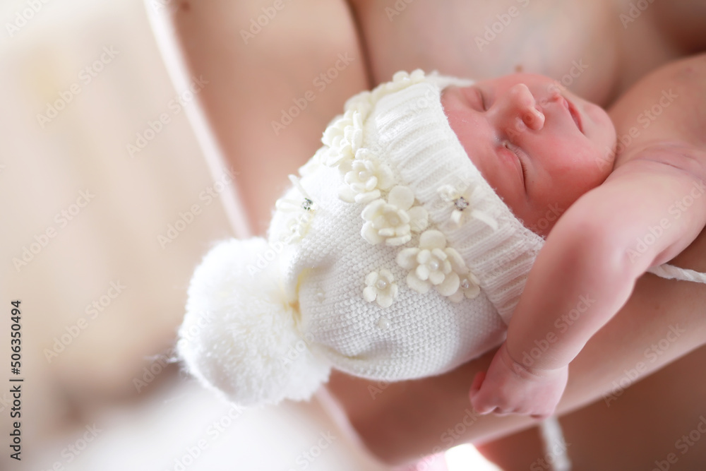 A newborn baby lies in her mother's arms. A beautiful baby of European appearance is sleeping. A newborn baby lies in her mother's arms. A beautiful baby of European appearance is sleeping.