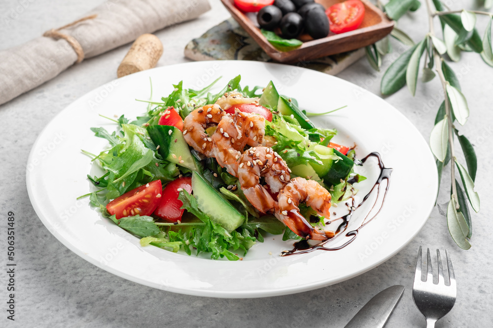 Grilled shrimp with green salad, tomatoes, cucumbers and arugula leaves, balsamic sauce and sesame seeds Grilled shrimp with green salad, tomatoes, cucumbers and arugula leaves, balsamic sauce and sesame seeds