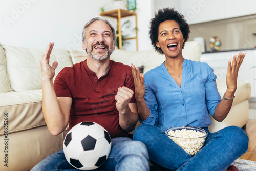 Couple sport fans watching football match on television