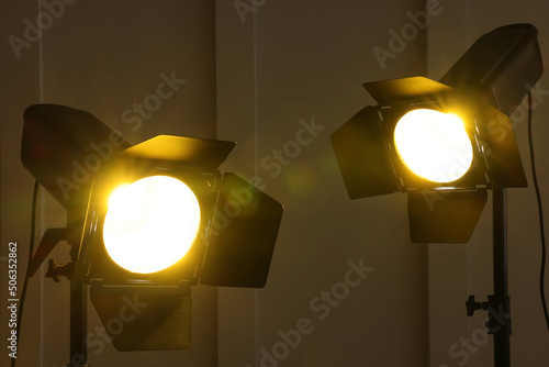 Bright yellow spotlights near wall indoors. Professional stage equipment