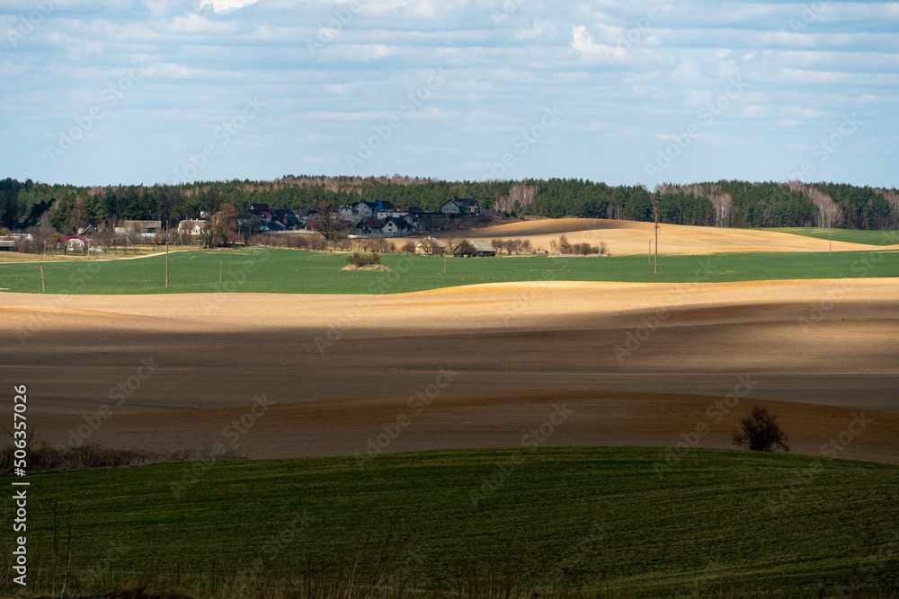 Obraz premium Agricultural field near major cities. Poor conditions for conducting agribusiness and growing crops in an unfavorable place. Environmental pollution.