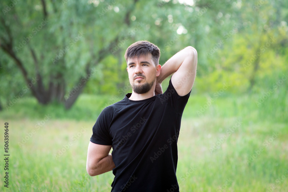 A male athlete stretches his hands in nature, close-up A male athlete stretches his hands in nature, close-up