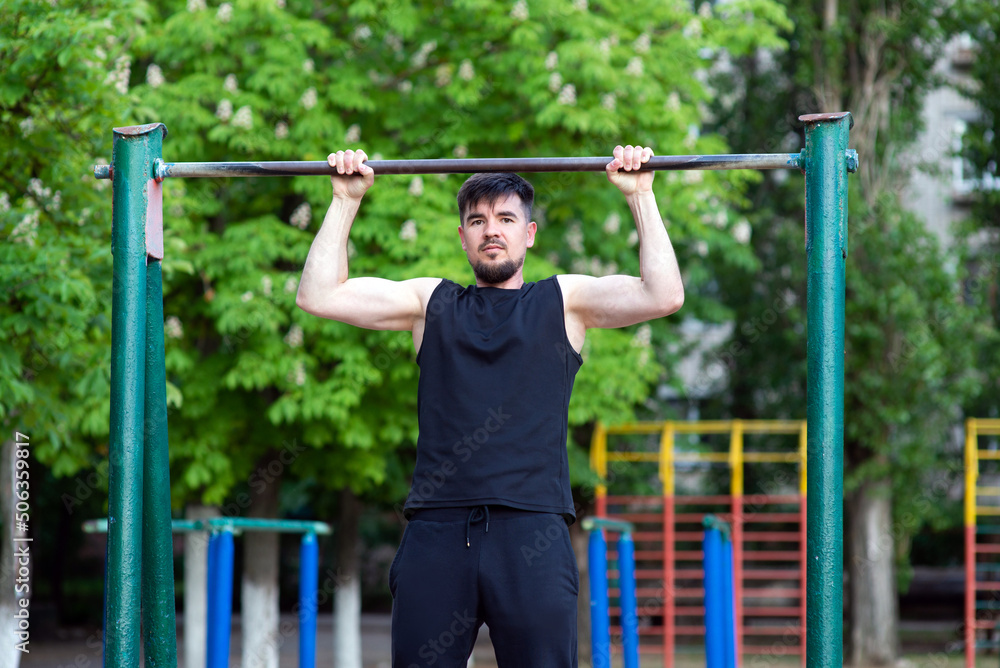 A male athlete is engaged in a horizontal bar, close-up