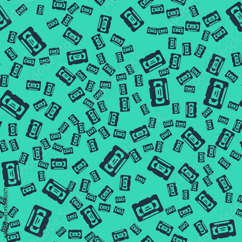 Black VHS video cassette tape icon isolated seamless pattern on green background. Vector