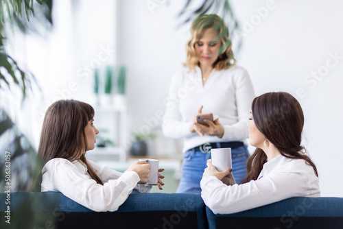 Three girls discuss news and drink tea in the apartment