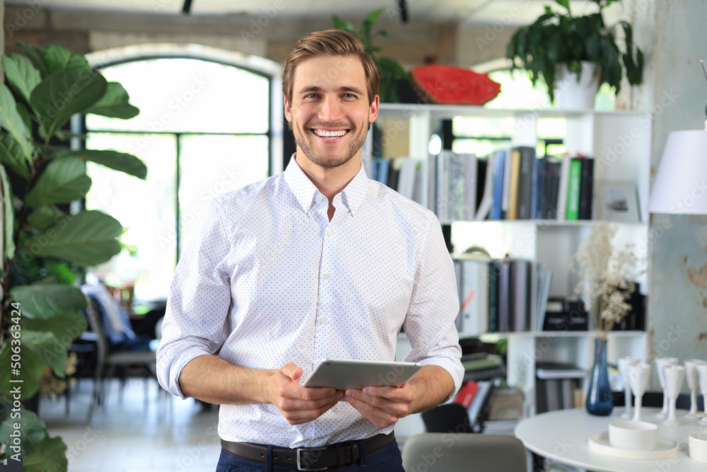 Fototapeta premium Handsome businessman using his tablet in the office.