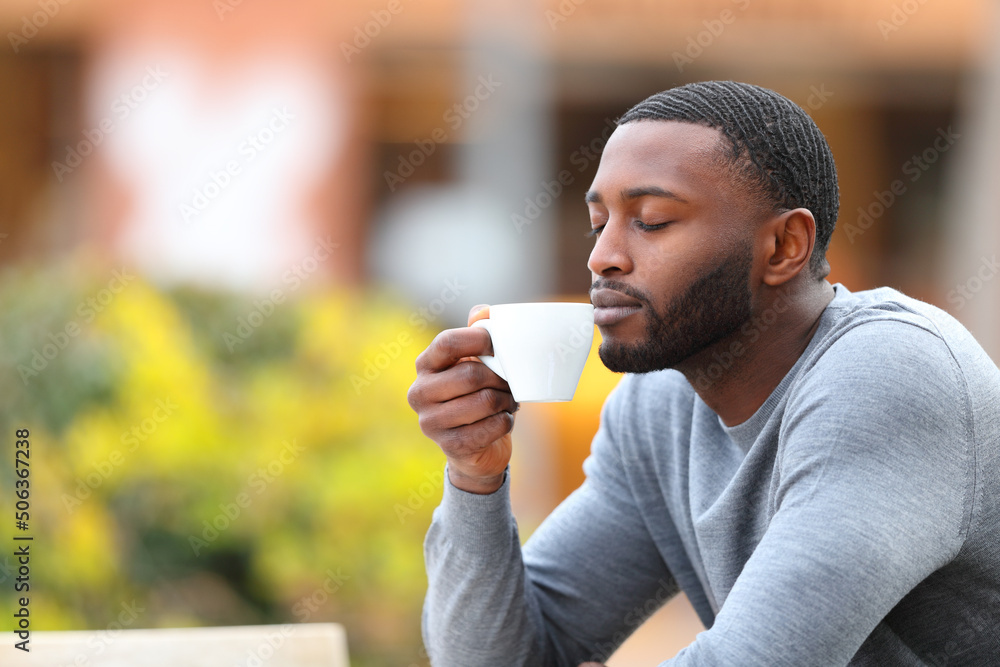 Man with black skin enjoying aroma of coffee cup Man with black skin enjoying aroma of coffee cup