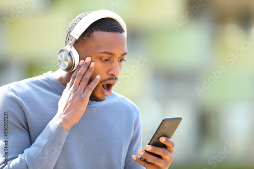 Shocked man with headphones and phone in the street photo