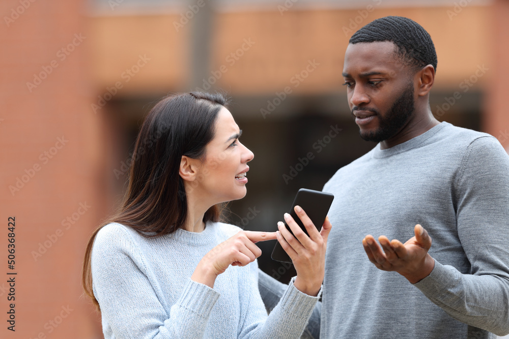Woman asking for explanation about phone text to a man Woman asking for explanation about phone text to a man