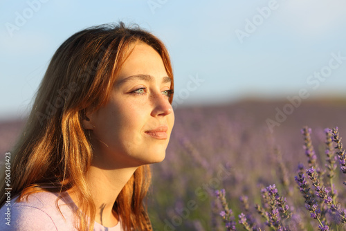 Woman relaxing contemplating sunset from lavender field photo