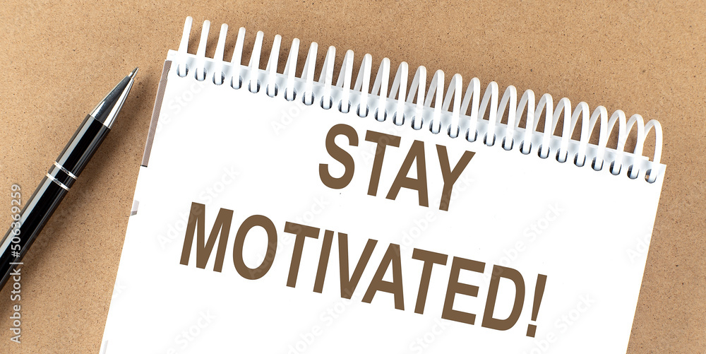 STAY MOTIVATED text on a notepad with pen, business STAY MOTIVATED text on a notepad with pen, business