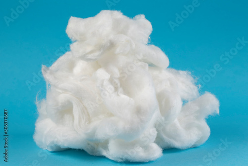 White piece of cotton wool on a blue background. Delicate cloud.Piece Cotton wool isolated on blue