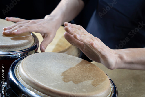 Hands of percussionist playing conga drum