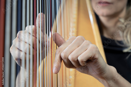 Hands of mature woman playing harp photo