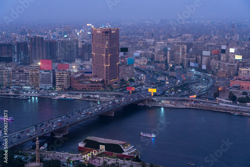 Egypt, Cairo, River Nile,QasrElNil Bridge and surrounding downtown buildingsat dusk photo