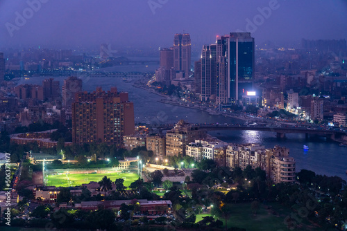 Egypt, Cairo, River Nile,Illuminated city park at dusk with river Nile and skyscrapers in background photo