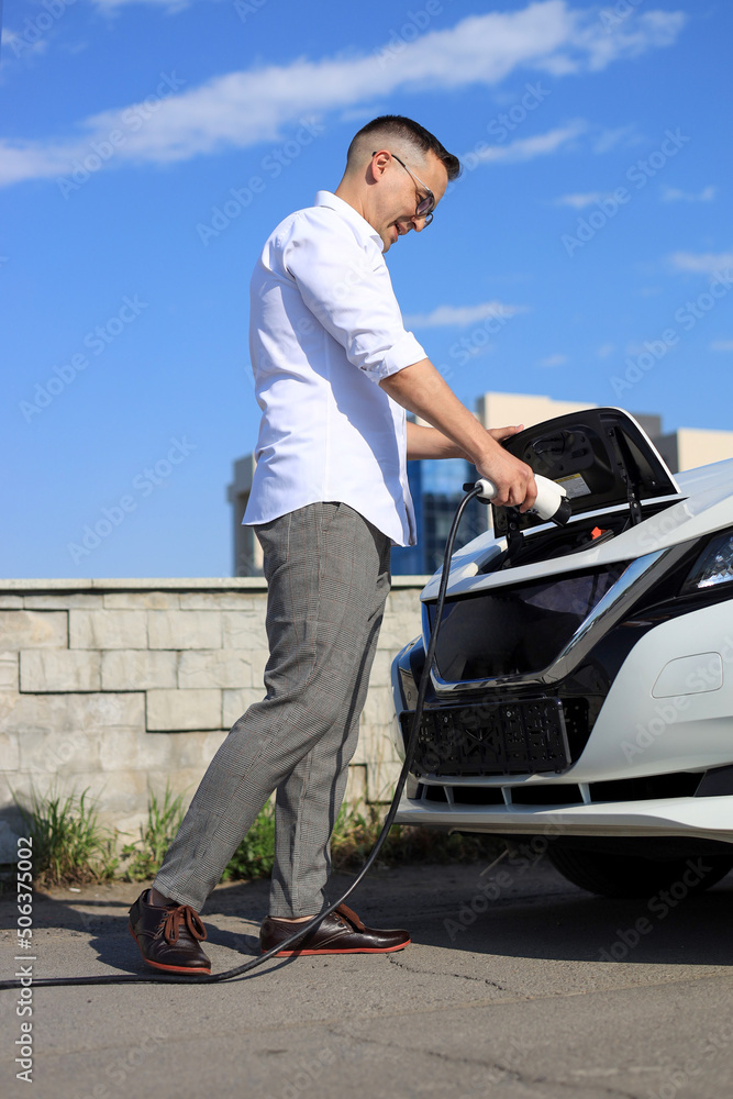 Man charging an electric car at an electric gas station Man charging an electric car at an electric gas station
