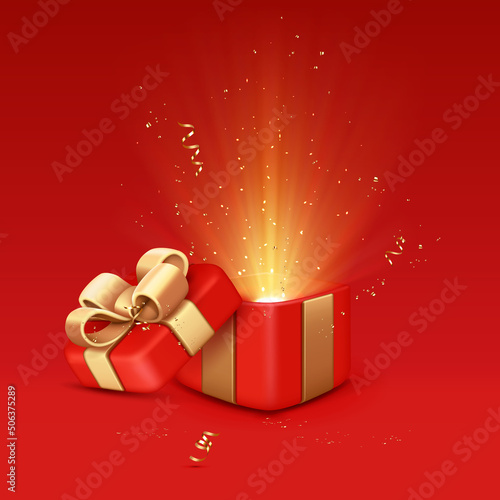 Open red gift box with golden ribbon and glow.