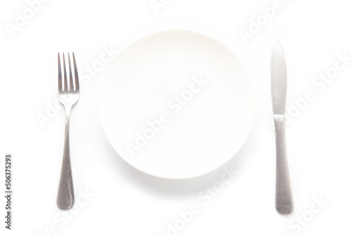 Empty white ceramic plate  knife and fork on a white table. For food  advertising space.