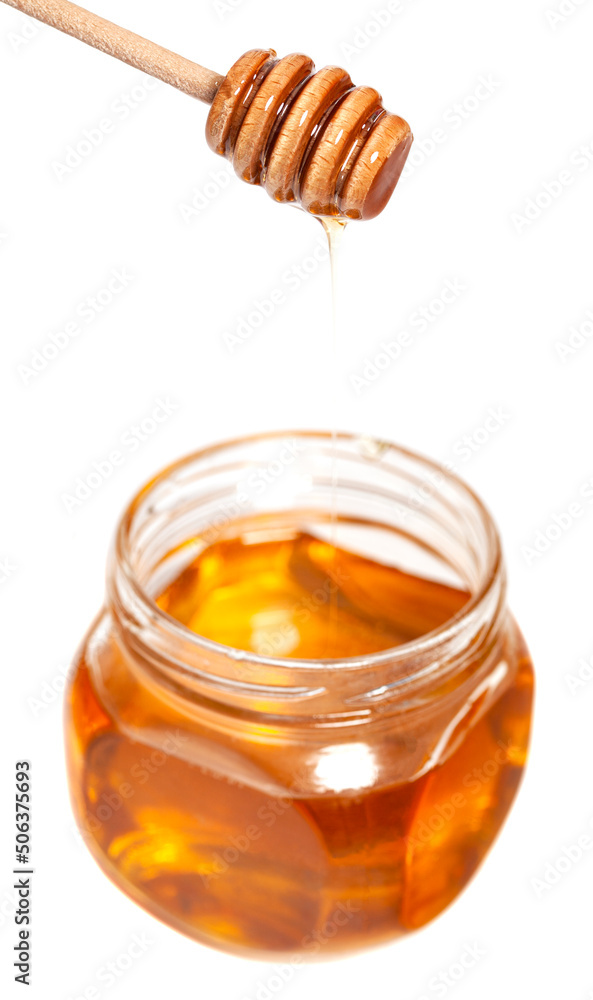 Honey dripping from honey dipper in glass jar. Healthy food concept Honey dripping from honey dipper in glass jar. Healthy food concept