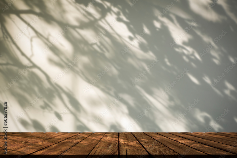Shadow table background. White wall with shadows plants and tree in sunlight with wooden rustic table. Shadow table background. White wall with shadows plants and tree in sunlight with wooden rustic table.