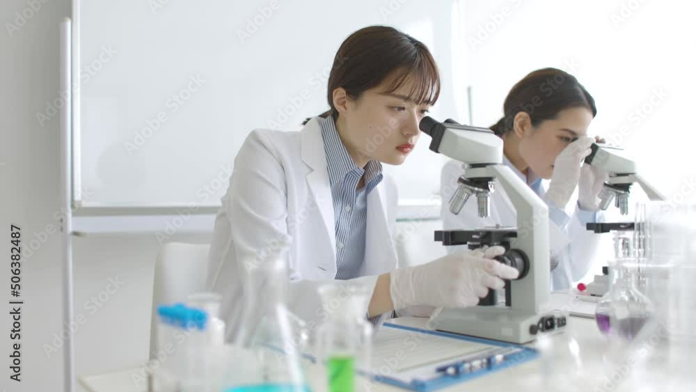 顕微鏡を覗く研究者の女性 顕微鏡を覗く研究者の女性