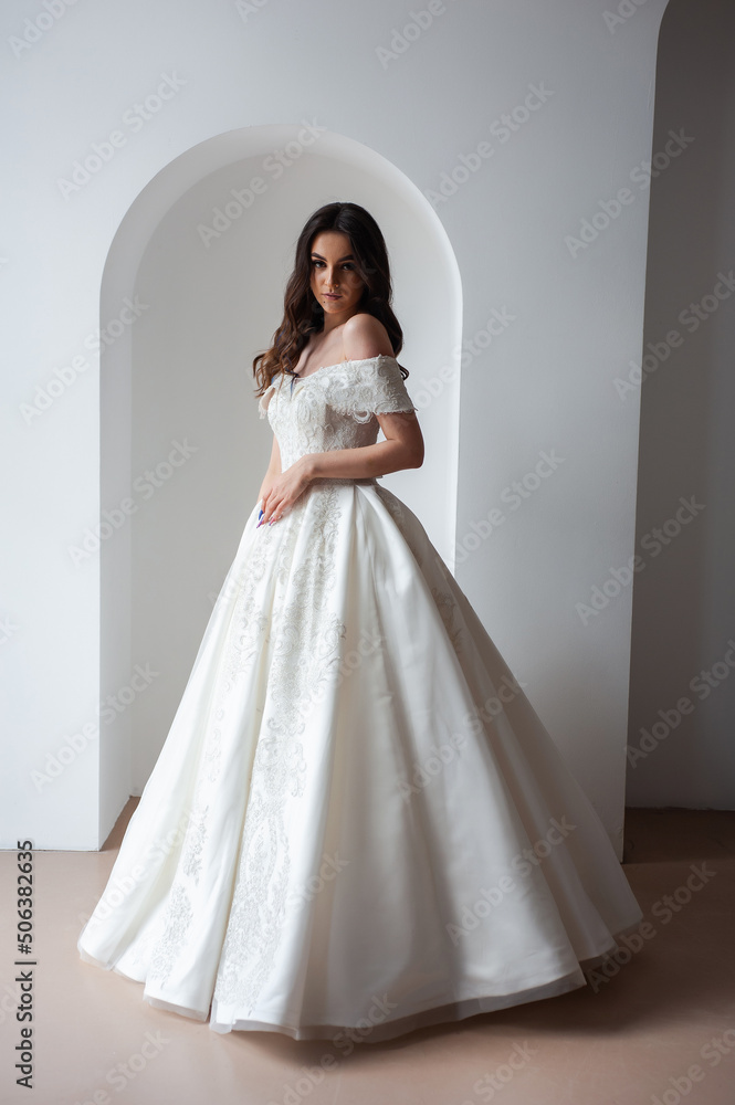Beautiful bride posing in wedding dress in a white photo Studio. Beautiful bride posing in wedding dress in a white photo Studio.