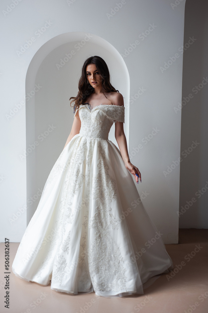 Beautiful bride posing in wedding dress in a white photo Studio.