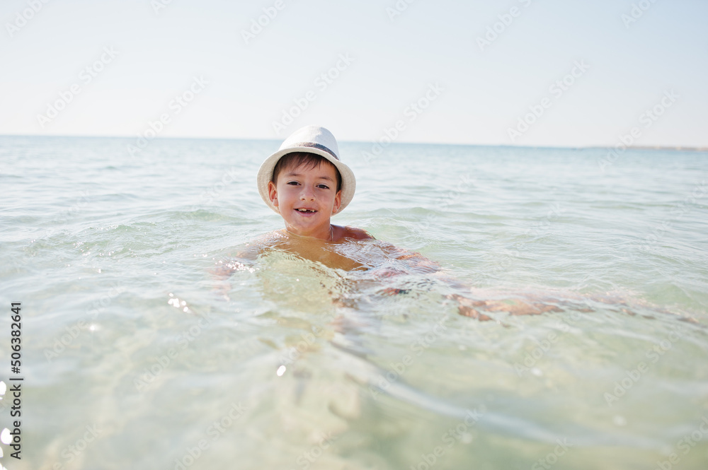 Boy wear panama hat swimming in Red sea.