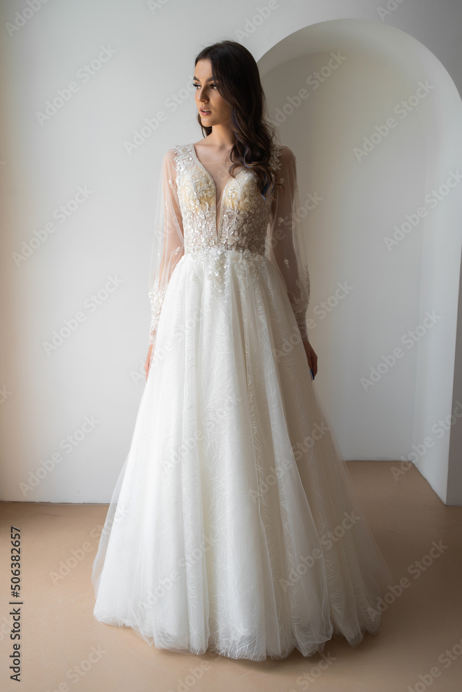 Beautiful bride posing in wedding dress in a white photo Studio. Beautiful bride posing in wedding dress in a white photo Studio.
