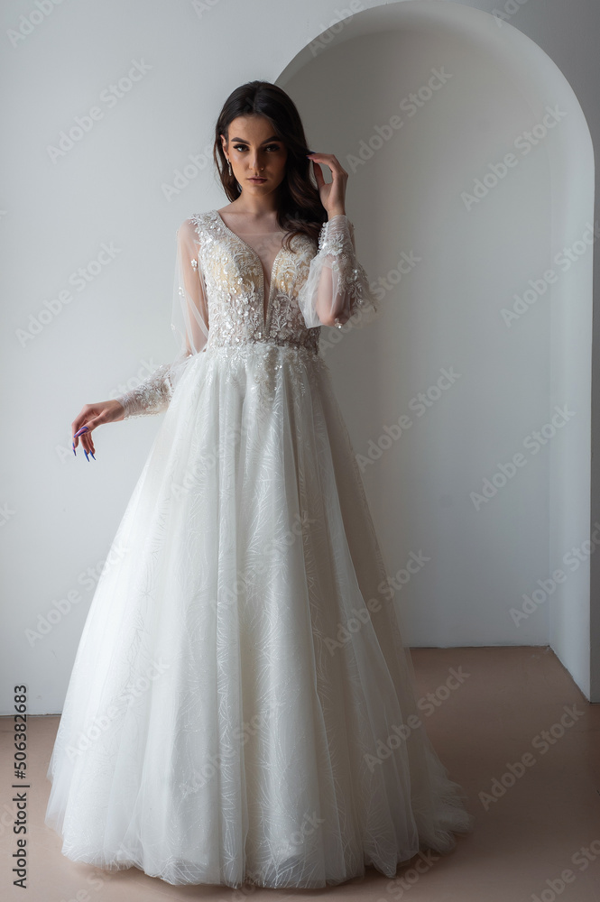 Beautiful bride posing in wedding dress in a white photo Studio.