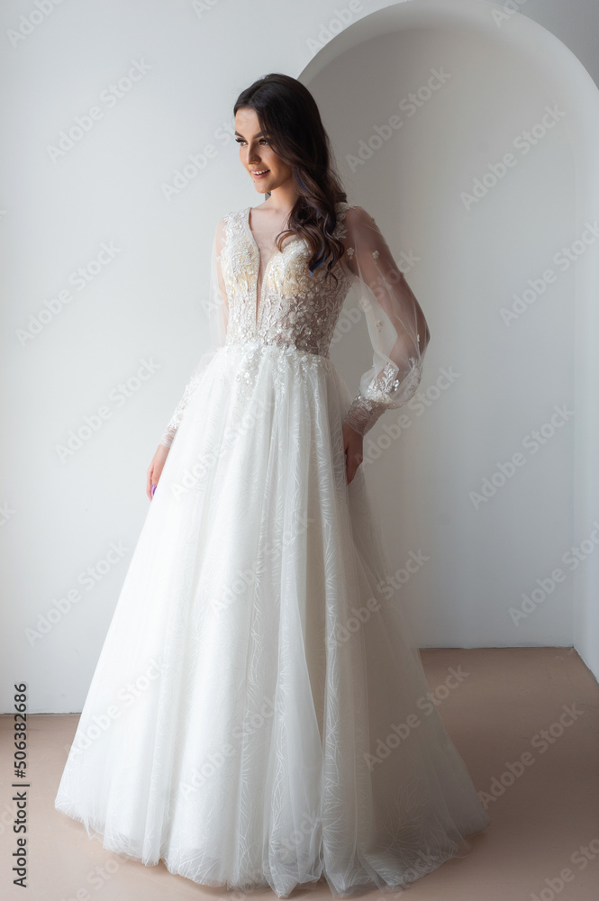 Beautiful bride posing in wedding dress in a white photo Studio. Beautiful bride posing in wedding dress in a white photo Studio.