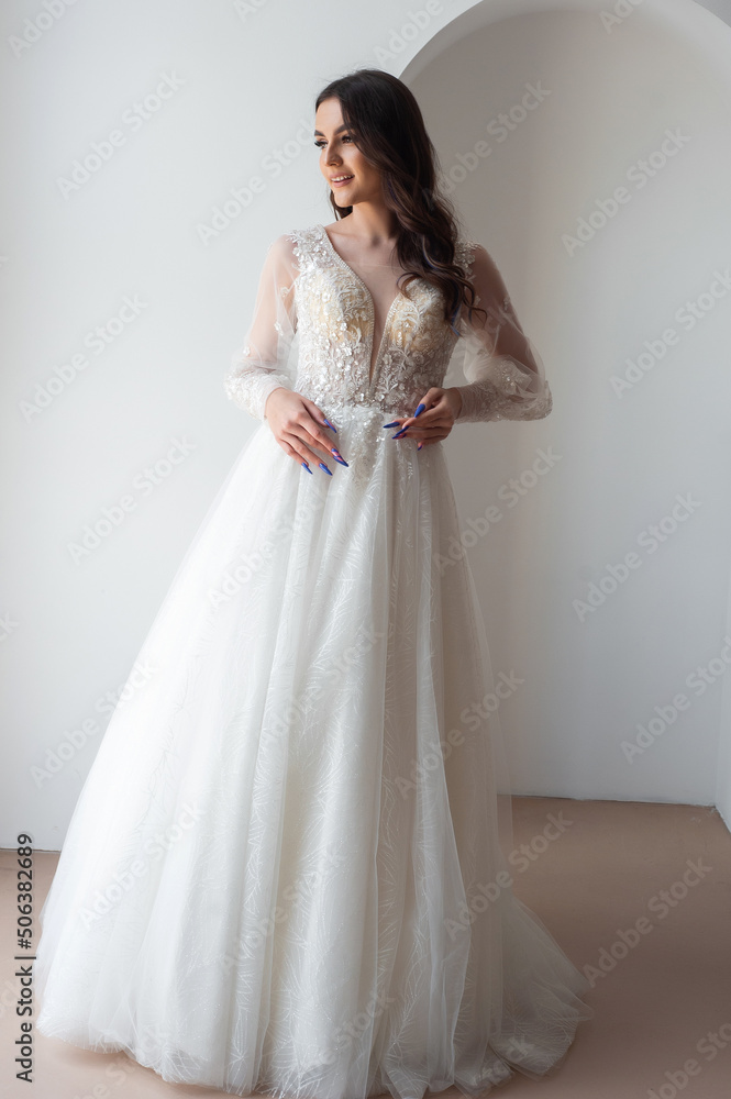 Beautiful bride posing in wedding dress in a white photo Studio.