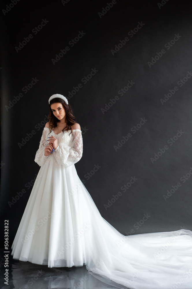 Full length portrait of young beautiful woman wearing white wedding dress. Elegant bride standing and posing Full length portrait of young beautiful woman wearing white wedding dress. Elegant bride standing and posing