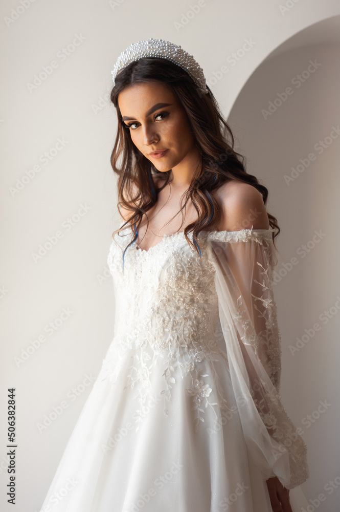 Full length portrait of young beautiful woman wearing white wedding dress. Elegant bride standing and posing Full length portrait of young beautiful woman wearing white wedding dress. Elegant bride standing and posing