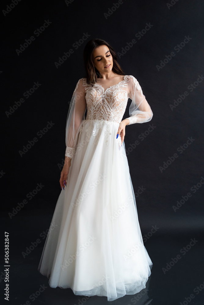 Full length portrait of young beautiful woman wearing white wedding dress. Elegant bride standing and posing Full length portrait of young beautiful woman wearing white wedding dress. Elegant bride standing and posing