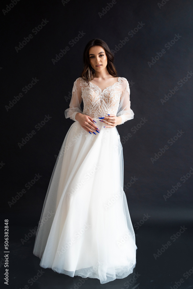 Full length portrait of young beautiful woman wearing white wedding dress. Elegant bride standing and posing Full length portrait of young beautiful woman wearing white wedding dress. Elegant bride standing and posing