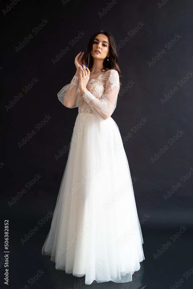 Full length portrait of young beautiful woman wearing white wedding dress. Elegant bride standing and posing Full length portrait of young beautiful woman wearing white wedding dress. Elegant bride standing and posing