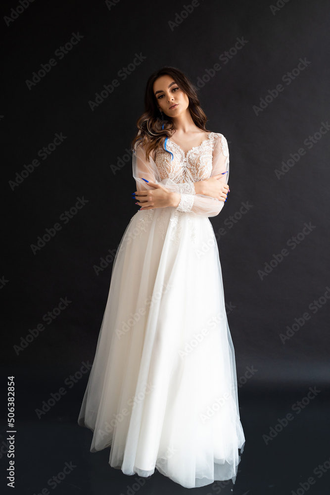 Full length portrait of young beautiful woman wearing white wedding dress. Elegant bride standing and posing Full length portrait of young beautiful woman wearing white wedding dress. Elegant bride standing and posing